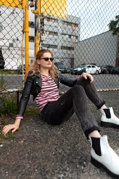 Femme punk avec des lunettes de soleil en milieu urbain