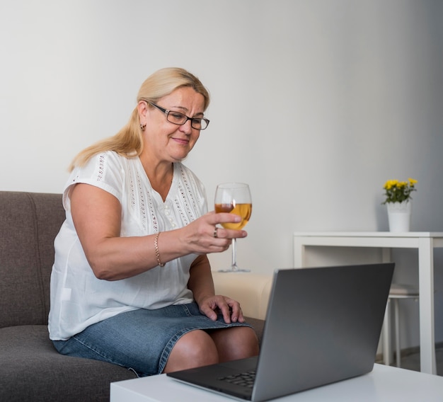 Femme en quarantaine, prendre un verre avec un ordinateur portable