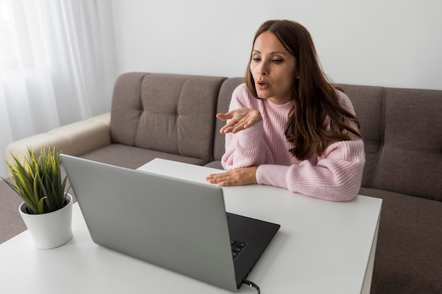 Femme en quarantaine soufflant des bisous aux gens sur un ordinateur portable