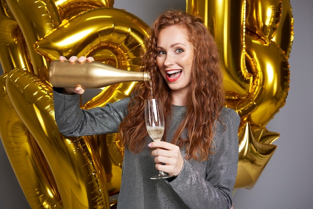 Femme qui crie versant du champagne au studio shot