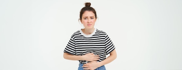 Photo gratuite une femme qui a faim touche son ventre une fille qui a des crampes menstruelles une douleur menstruelle tient les mains