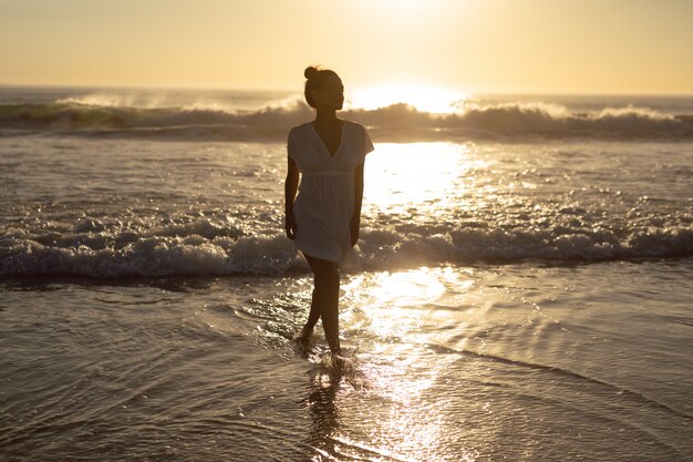 Femme qui marche sur la mer à la plage