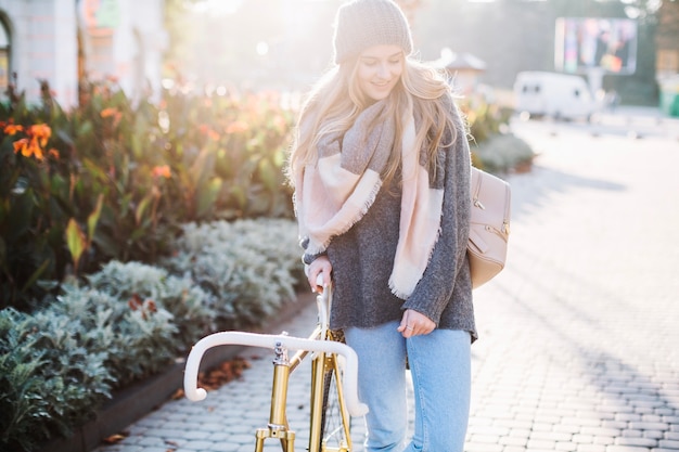 Femme qui marche près de vélo dans le parc