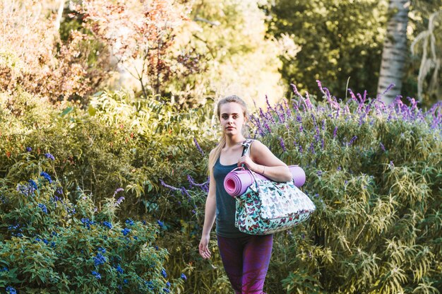 Femme qui marche avec sac et tapis d&#39;étirement