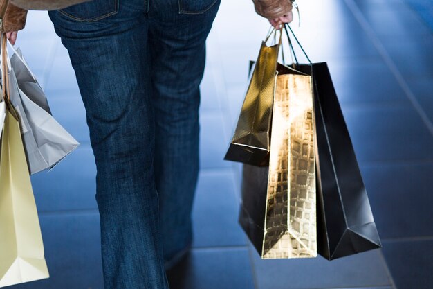 Femme qui marche avec des sacs à provisions brillants