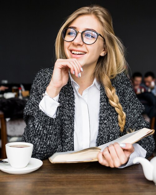 Femme qui riante avec livre