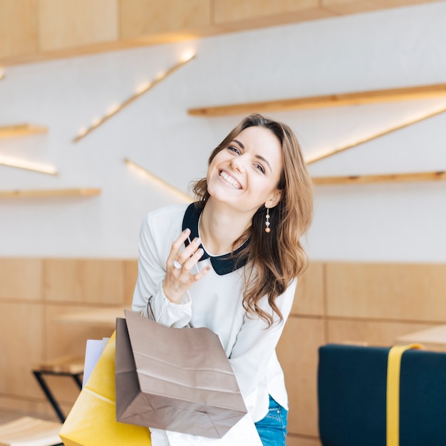 Femme qui riante avec des sacs en papier