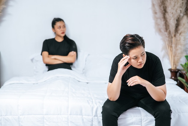 Une femme qui s'aime se met en colère et s'assoit sur le lit.