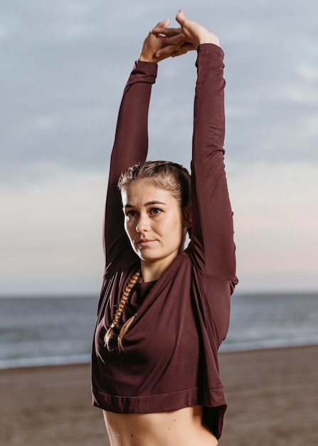 Femme qui s'étend au bord de la plage