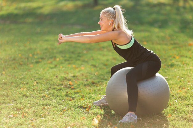 Femme qui s'étend sur une balle de gymnastique