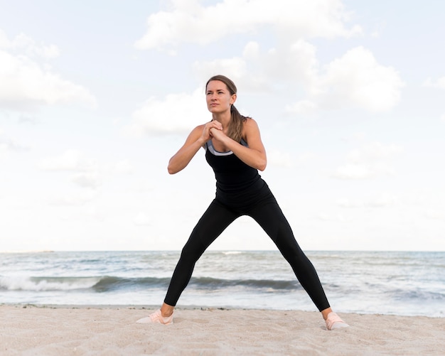 Femme qui s'étend sur la plage