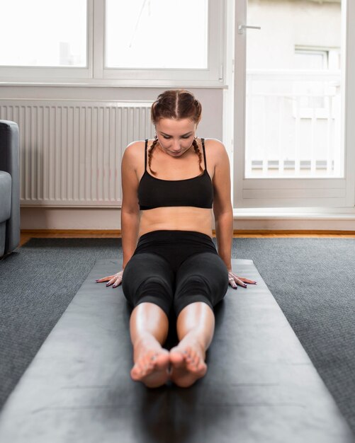 Femme qui s'étend ses jambes à l'intérieur