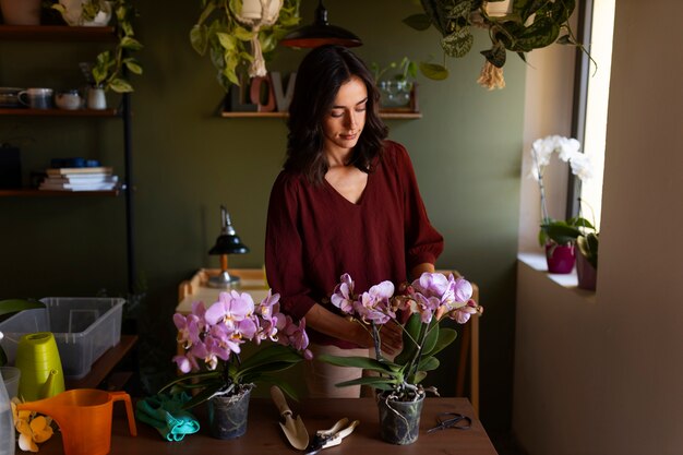 Une femme qui s'occupe d'une orchidée exotique