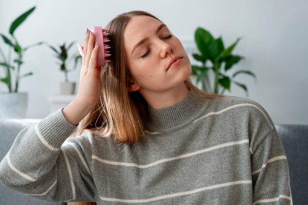 Une femme qui se fait un massage du cuir chevelu.