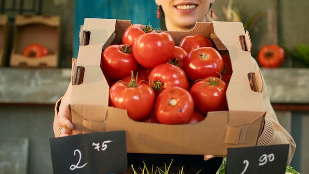 Photo gratuite une femme qui tient un stand au marché local