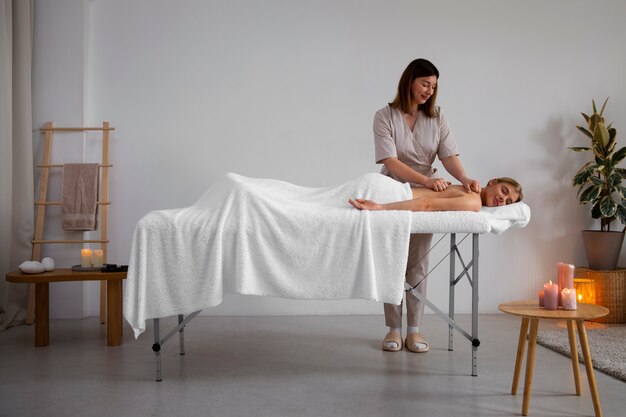 Femme recevant un massage du dos par un masseur