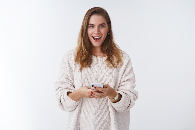 femme recevant un message curieux souriant mystérieux tenant un smartphone heureux, messagerie communiquant en ligne