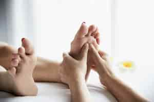 Photo gratuite femme recevant un service de massage des pieds de la masseuse se bouchent les pieds et les mains - concept de service de massage