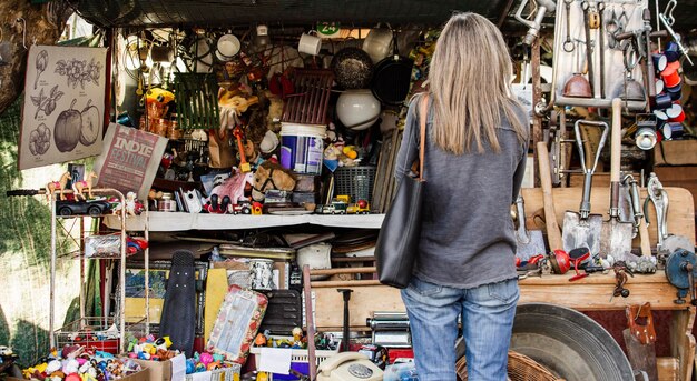 Femme à la recherche de quelque chose à acheter dans un marché d'antiquités