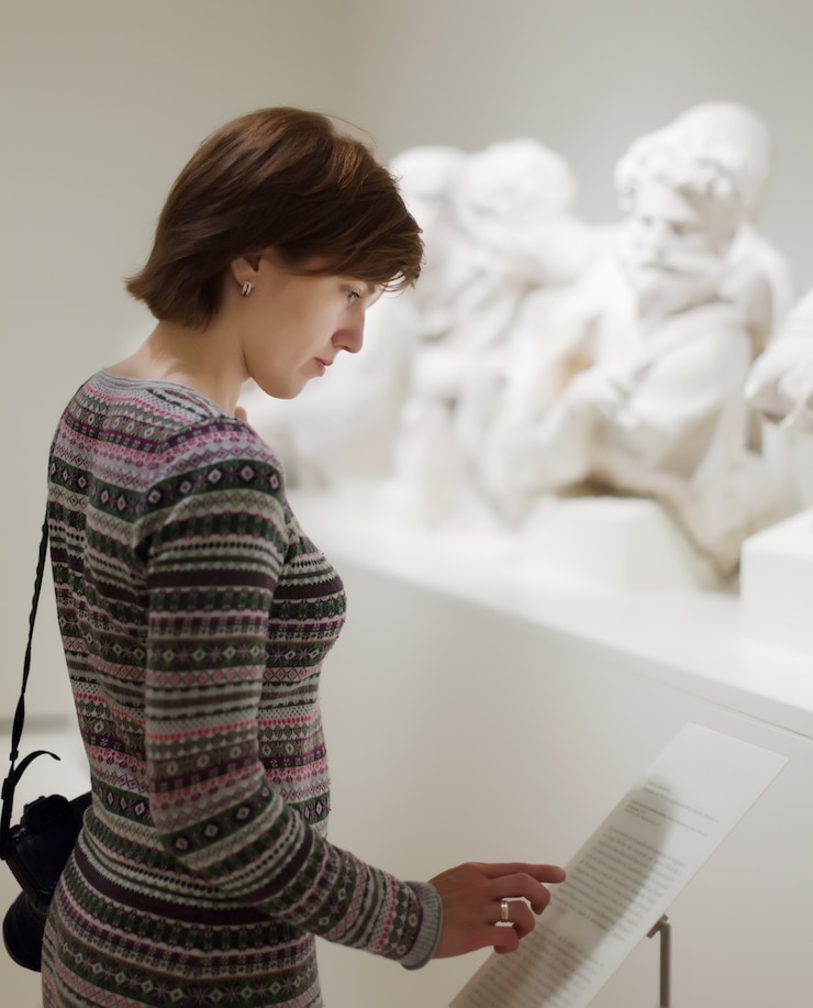 Photo gratuit femme à la recherche de sculptures anciennes