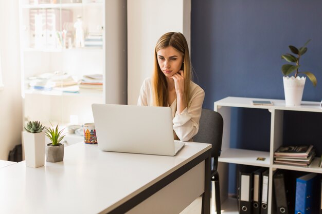 Femme réfléchie à l&#39;aide d&#39;un ordinateur portable