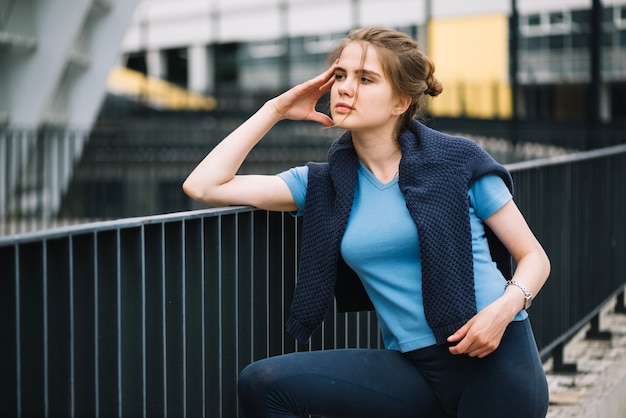 Femme réfléchie à la balustrade