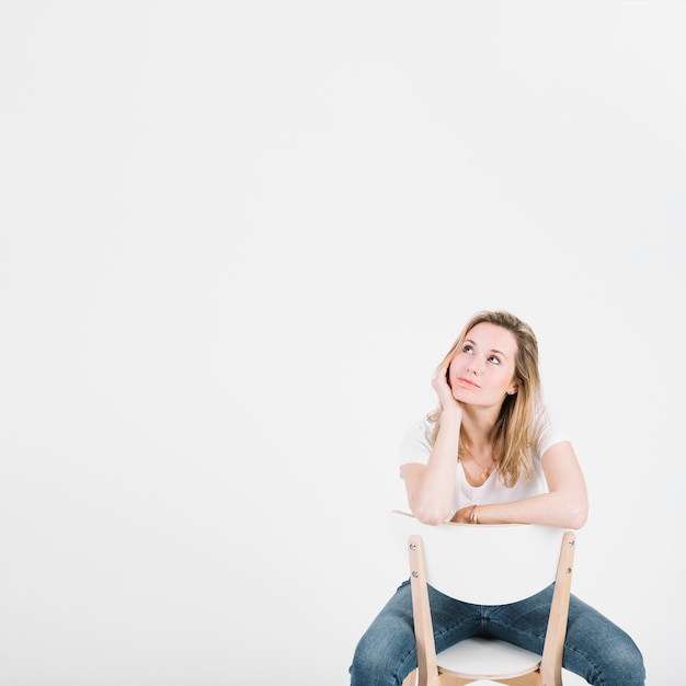 Femme réfléchie sur une chaise