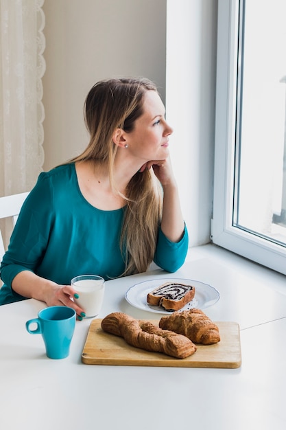 Photo gratuite femme réfléchie avec du lait