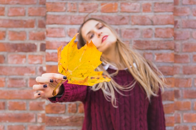 Photo gratuite femme réfléchie avec des feuilles d'automne