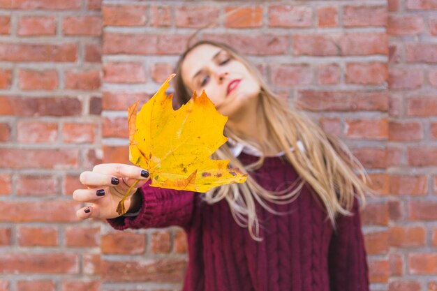 Femme réfléchie avec des feuilles d&#39;automne