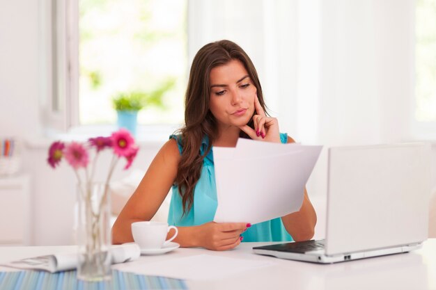 Femme réfléchie travaillant à la maison