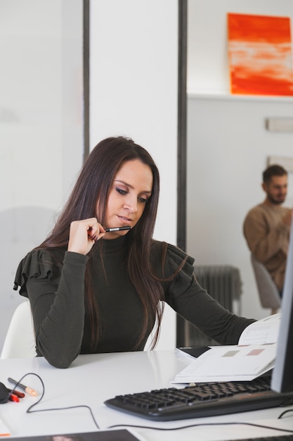 Photo gratuite femme réfléchie travaillant avec des papiers