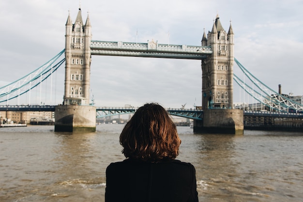Femme regardant le célèbre Tower Bridge St UK pendant la journée Tower Bridge au Royaume-Uni