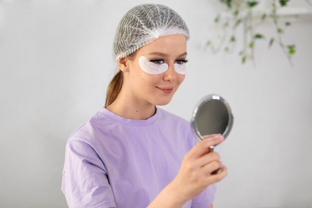 Femme regardant dans le miroir vue latérale