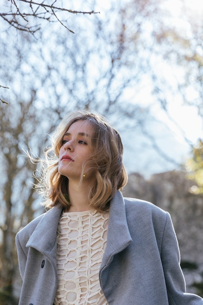 Femme regardant de loin avec les cheveux en désordre