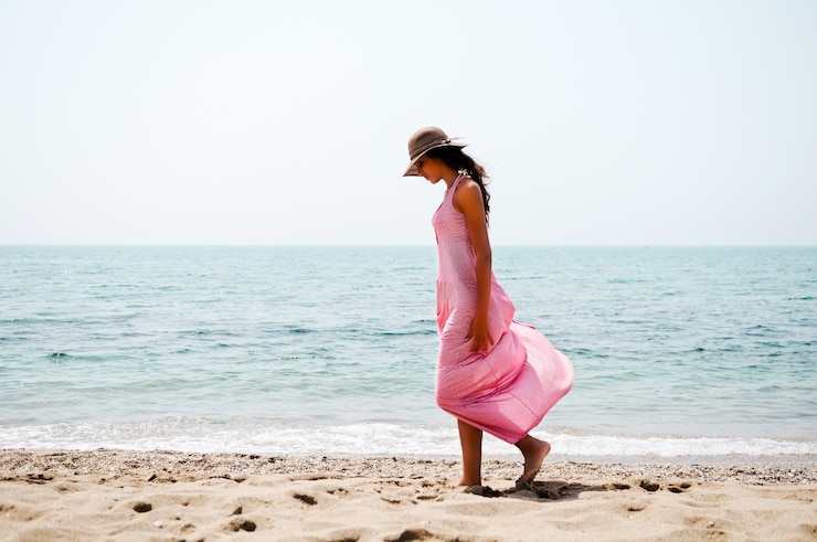 Photo gratuit femme regardant la plage de sable en marchant