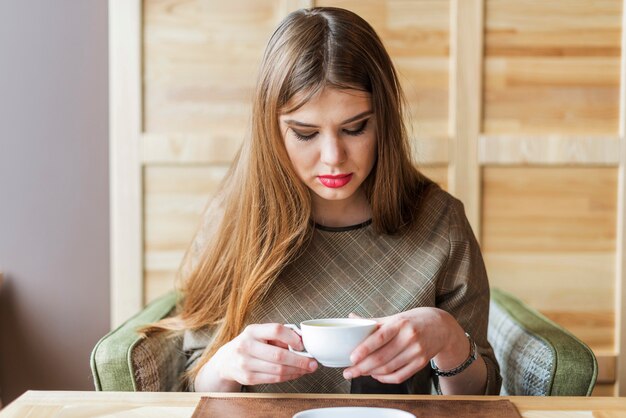 Femme regardant sa tasse de thé