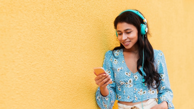 Femme regardant son téléphone et sourire avec espace copie