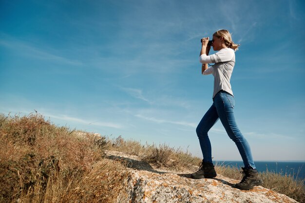 Femme regardant à travers des jumelles