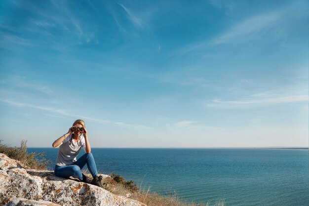 Femme regardant à travers des jumelles