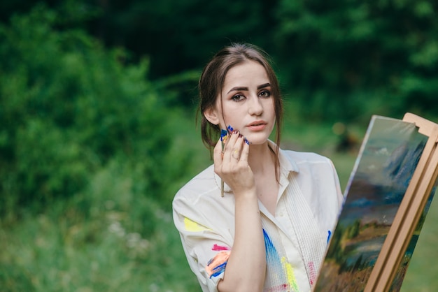 Femme regardant vers l&#39;avant avec un pinceau dans sa main