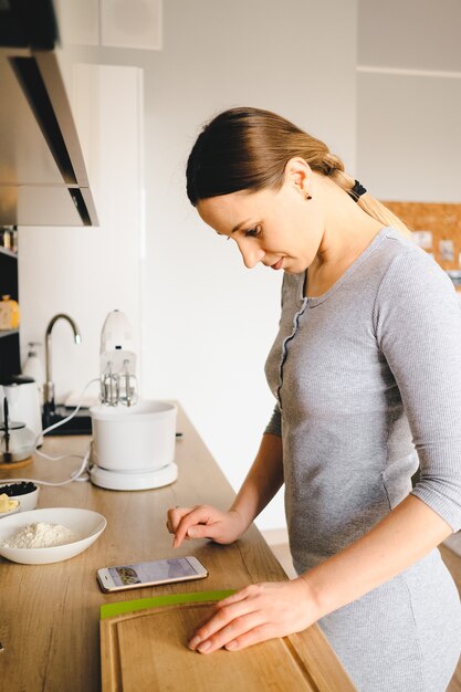 Femme regarde la recette au téléphone