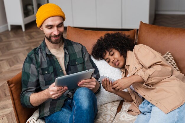 Femme, regarder téléphone, et, homme travaille, sur, tablette