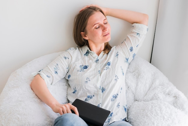 Femme relâche, sur, a, doux, sac pouf, chaise