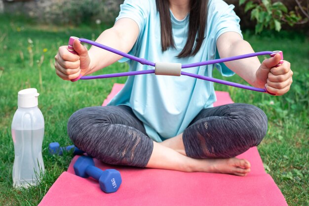 Femme de remise en forme faisant de l'exercice avec un élastique de remise en forme à l'extérieur