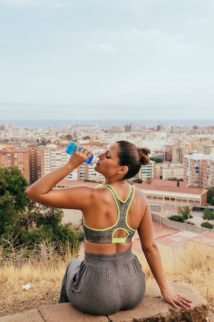 Photo gratuite femme reposant et buvant après le sport