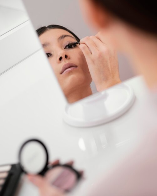 Femme restant à la maison et utilisant du maquillage