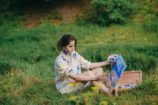 Femme retoucher une photo assis sur l&#39;herbe