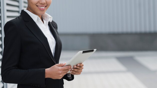 Femme réussie tenant ipad se bouchent