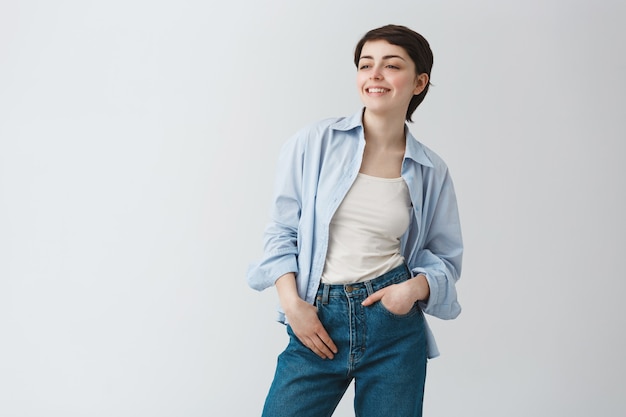 Femme rêveuse insouciante en détournant les yeux avec un sourire heureux et heureux